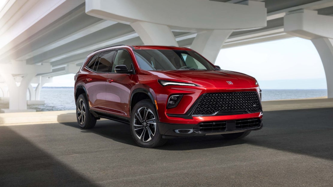 A red Buick Enclave parked underneath a bridge.