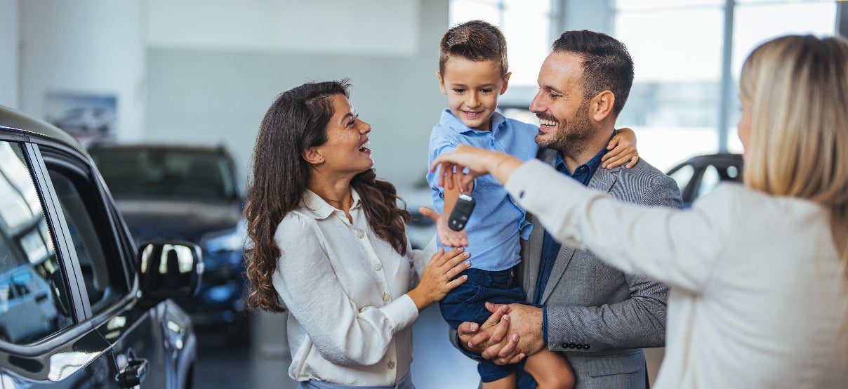 A young family getting the keys to their new vehicle