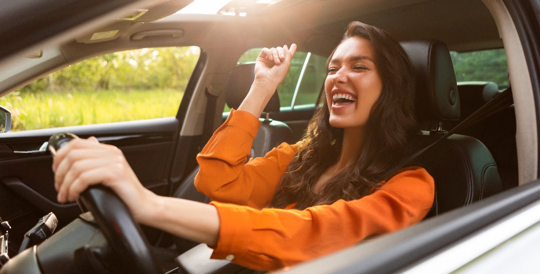 Happy young woman enjoying her used Buick